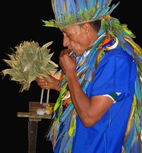 Taita Alfredo playing the harmonica during a Yage ritual. Photo: J. Imbachi Ⓒ El Mundo Magico